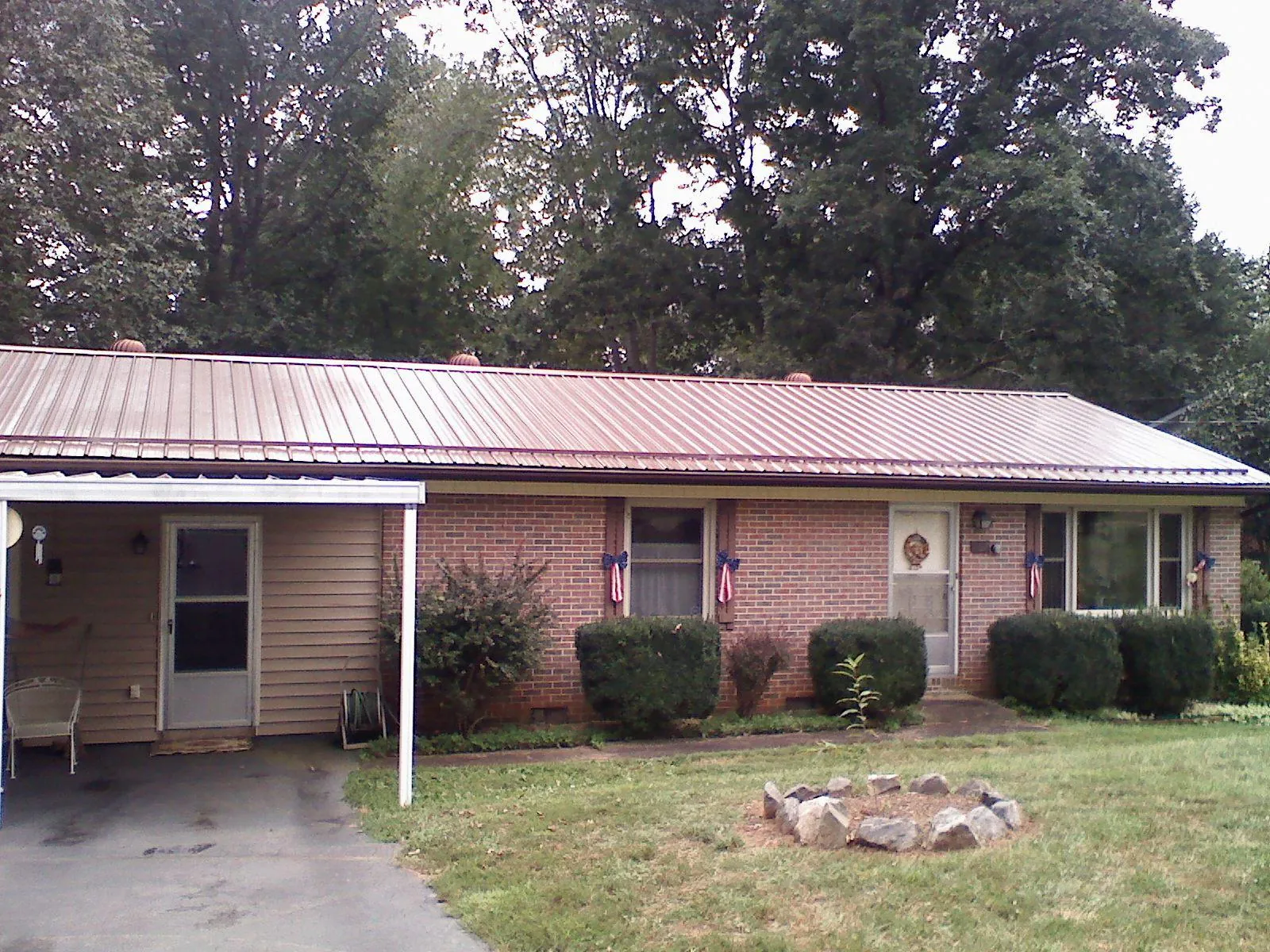 Bronze metal roof and carport on a brick ranch home — Roof Repair work by our crew in Brownell