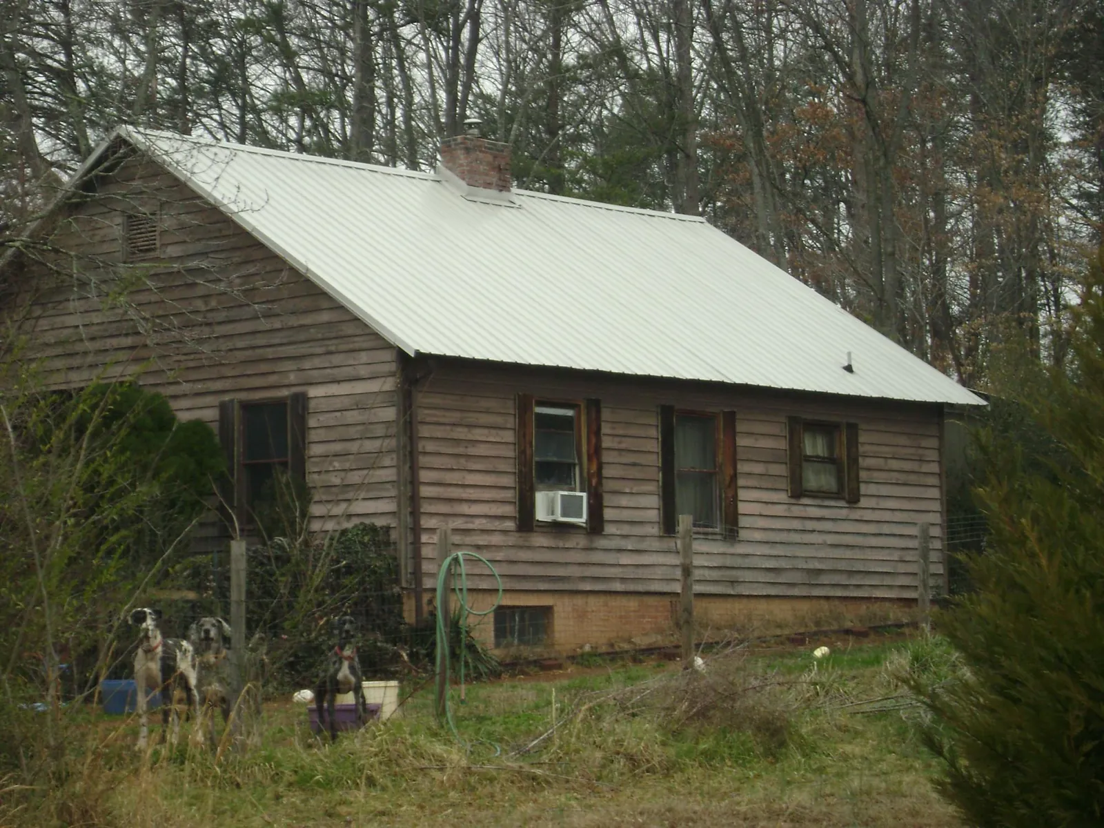 White metal roof on an old wood sided farmhouse, from a Metal Roof Installation job in Brownell